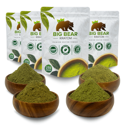 Four 250 gram Big Bear Kratom Pouches in a row behind four bowls of kratom powder.