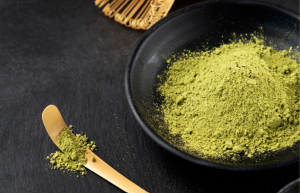 Green kratom powder in a bowl illustrating the raw material used in extract concentration process]