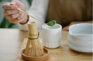 Person holding a spoon with green kratom powder